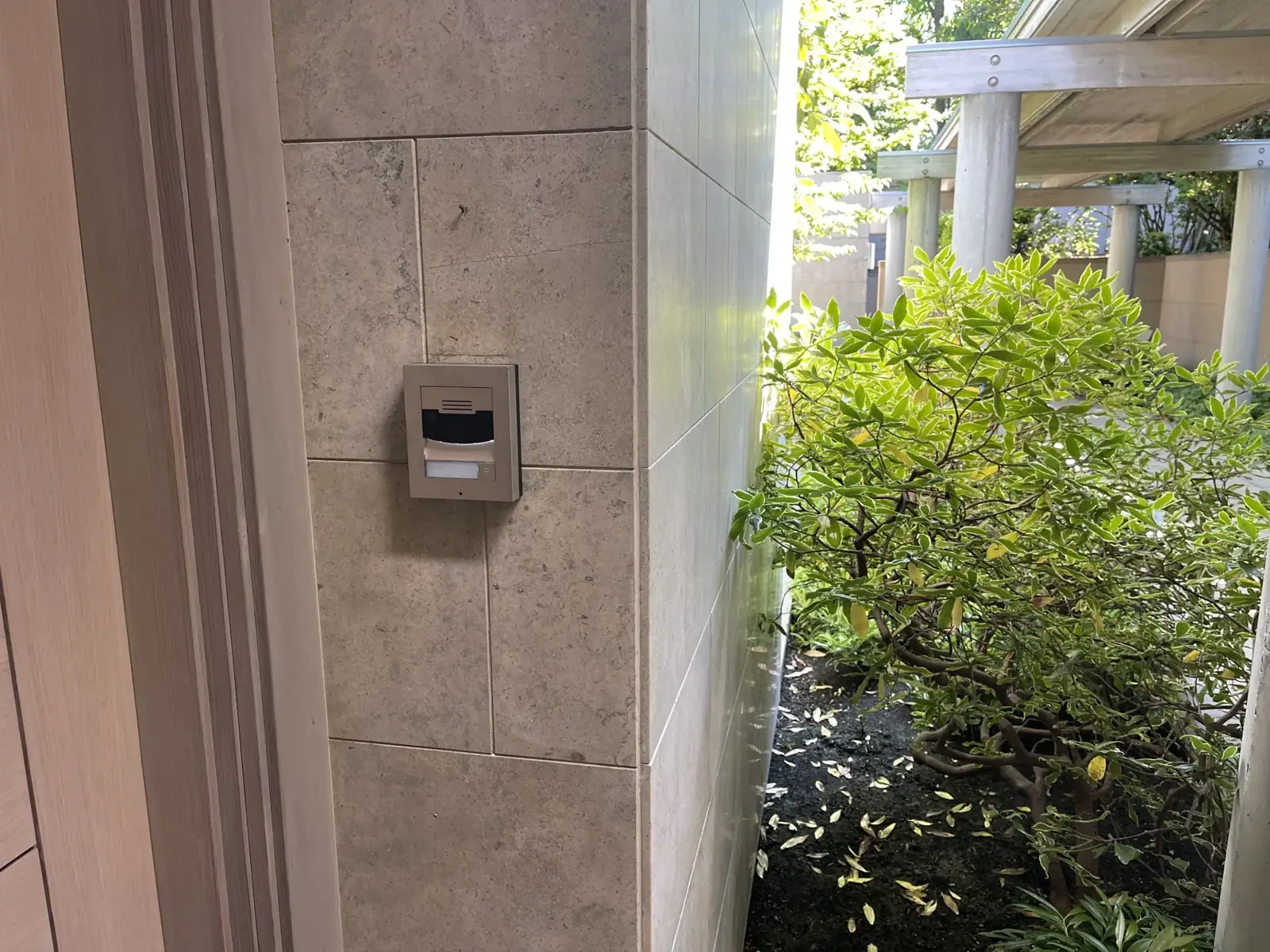 Discreet video intercom set in a stone wall by the entry, Mercer Island