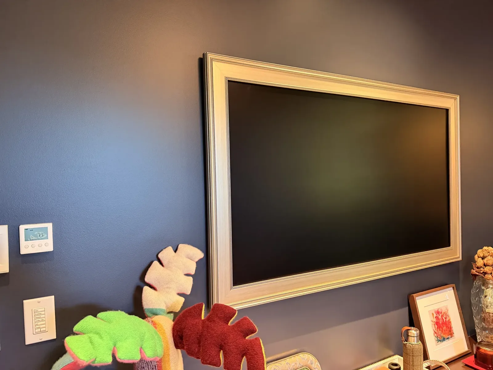 TV in a picture frame on a navy wall with a control keypad beside it, Mercer Island
