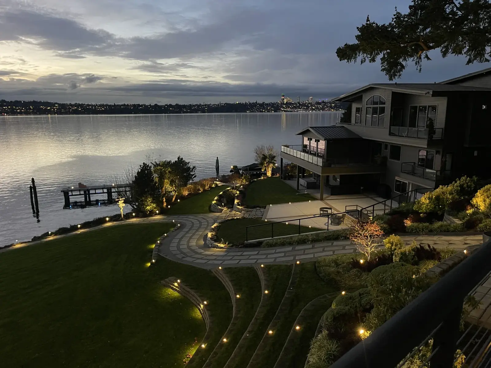 Lit lakeside terraces and lawn at dusk, Mercer Island