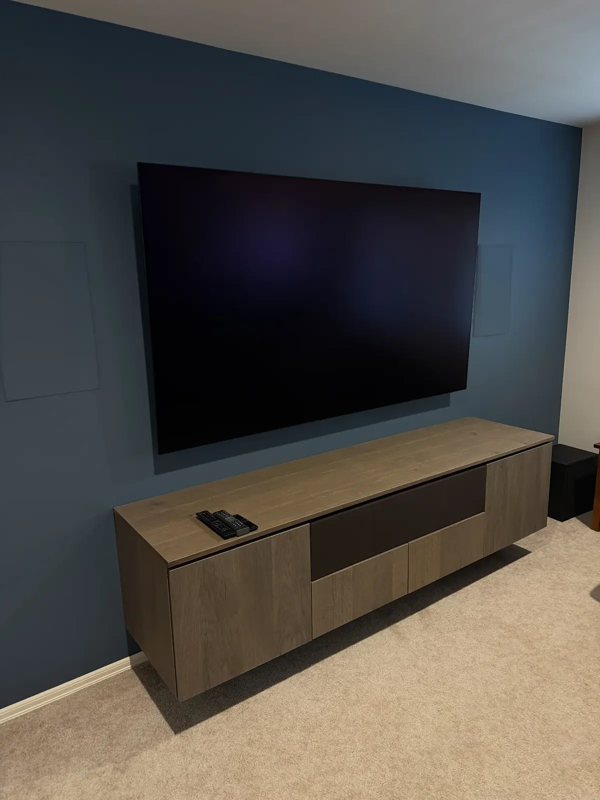 Wall-mounted TV with in-wall speakers and floating media cabinet, Mill Creek, with Tenhulzen Construction