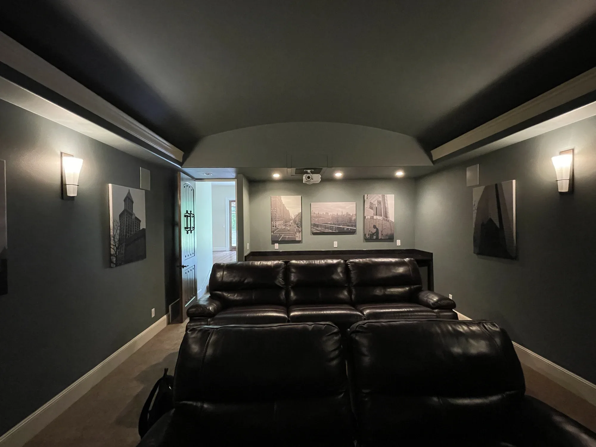Leather recliners in a dark green home theater with wall sconces, Redmond