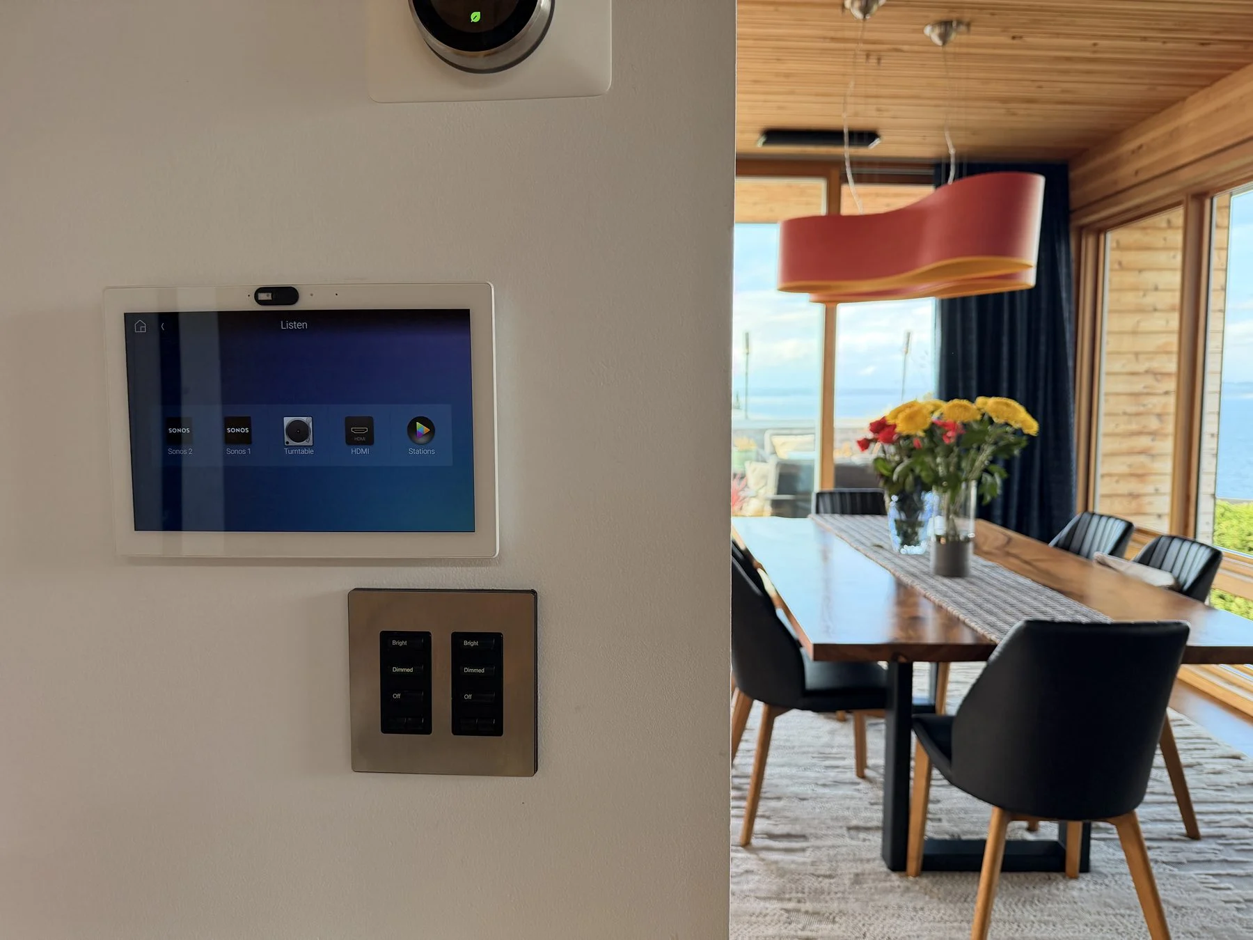 Wall touchscreen and keypad beside a dining room with a view, Seattle