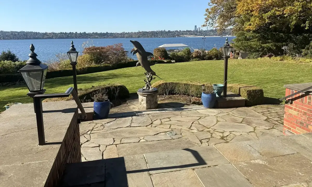 Stone terrace with lamp posts above a lake